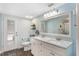 Bright bathroom with double sink vanity, large mirror, and a door to the exterior at 202 Sweetwater Club Blvd, Longwood, FL 32779