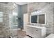 Stylish bathroom featuring double sinks, stone accent wall, and glass-enclosed shower, creating a spa-like experience at 202 Sweetwater Club Blvd, Longwood, FL 32779