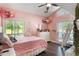 This bedroom features pink walls, wood-look floors and ladder to the loft area at 202 Sweetwater Club Blvd, Longwood, FL 32779