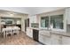 Bright kitchen featuring a farmhouse sink, granite countertops, and modern appliances with a view to an adjacent living space at 202 Sweetwater Club Blvd, Longwood, FL 32779