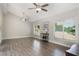 Bright living room with wood floors, vaulted ceiling, two ceiling fans, and view of the fenced backyard at 202 Sweetwater Club Blvd, Longwood, FL 32779