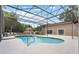 The screened-in pool features plenty of seating, landscaping, and clear blue skies at 202 Sweetwater Club Blvd, Longwood, FL 32779