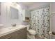 Updated bathroom featuring modern vanity, decorative mirror, and a shower with butterfly-themed curtain at 208 Madeira Ave, Orlando, FL 32825