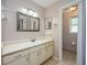 Bright bathroom features a vanity with ample storage, a large mirror, and neutral tile flooring at 208 Madeira Ave, Orlando, FL 32825