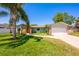 Charming single-story home with a well-manicured lawn, stone accents, and a mature palm tree at 208 Madeira Ave, Orlando, FL 32825
