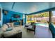 A covered lanai with a blue ceiling leads to the pool area featuring comfortable seating for relaxation and entertainment at 208 Madeira Ave, Orlando, FL 32825