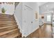 Hallway leading to staircase and modern kitchen area featuring wood floors and white walls at 2162 Lake Howell Preserve Ct, Maitland, FL 32751