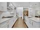 Bright modern kitchen features white cabinets, an island, stainless appliances, and hardwood floors at 2162 Lake Howell Preserve Ct, Maitland, FL 32751