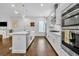 Open-concept kitchen with white cabinets, stainless appliances, and hardwood floors at 2162 Lake Howell Preserve Ct, Maitland, FL 32751