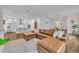 Open-concept living room featuring a brown leather sectional couch, kitchen with island and a dining area at 2162 Lake Howell Preserve Ct, Maitland, FL 32751