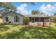 Relaxing backyard featuring a screened patio, lush lawn, and mature trees, perfect for outdoor enjoyment at 2277 Clearwater Dr, Deltona, FL 32738