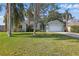 Charming single-story home with a well-manicured lawn, palm trees, and attached two-car garage at 2277 Clearwater Dr, Deltona, FL 32738