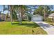 Well-kept single-story home with palm trees, green lawn, and attached two-car garage at 2277 Clearwater Dr, Deltona, FL 32738