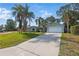 Inviting single-story home featuring a well-maintained lawn, palm trees, and a concrete driveway at 2277 Clearwater Dr, Deltona, FL 32738