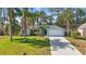 Attractive single-story home with a well-kept lawn and mature palm trees on a sunny day at 2277 Clearwater Dr, Deltona, FL 32738