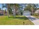 Charming single-story home featuring a well-manicured lawn, two car garage and lush tropical landscaping at 2277 Clearwater Dr, Deltona, FL 32738