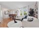 Bright living room boasts a white sofa, hardwood floors, large windows, and a vintage piano at 2277 Clearwater Dr, Deltona, FL 32738