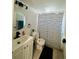 Bathroom featuring decorative vanity, shower with curtain, and round mirror at 2301 Oak Park Way # 101, Orlando, FL 32822