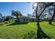 Sunny backyard features a lush lawn and mature trees, providing privacy and shade at 2314 Pennsylvania Ave, Oviedo, FL 32765