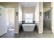 Bright bathroom with a standalone soaking tub, a decorative tile accent and a glass enclosed shower at 2314 Pennsylvania Ave, Oviedo, FL 32765