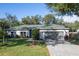 Charming single-story home with a gray exterior, a well-manicured lawn, and a paved driveway leading to a two-car garage at 2314 Pennsylvania Ave, Oviedo, FL 32765