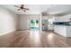 Open floorplan with hardwood flooring, view into kitchen and outdoor access via glass slider at 2314 Pennsylvania Ave, Oviedo, FL 32765