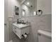 Bright bathroom with a marble counter vanity, toilet and white marble tiles on the walls at 2487 Harbour Way, Winter Park, FL 32792