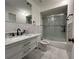 Bright bathroom with a marble countertop vanity, modern fixtures, and a glass-enclosed shower over tub at 2487 Harbour Way, Winter Park, FL 32792