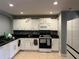 Functional kitchen featuring white cabinets, black countertops, and standard appliances at 2487 Harbour Way, Winter Park, FL 32792