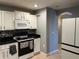Functional kitchen with white cabinets, black countertops, and modern appliances at 2487 Harbour Way, Winter Park, FL 32792