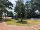 Community tennis court featuring mature trees, shade, and an adjacent picnic table at 2487 Harbour Way, Winter Park, FL 32792