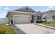 Inviting home featuring a two car garage, well-kept lawn, and beautifully landscaped front yard at 2515 W End Dr, St Cloud, FL 34772