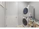 Functional laundry room with stacked washer and dryer, a convenient storage rack, and a clean white door at 2515 W End Dr, St Cloud, FL 34772