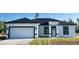 Charming single-story home featuring a two-car garage, white exterior, and black trim at 273 Marion Oaks Golf Rd, Ocala, FL 34473