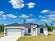 Charming single-story home featuring a two-car garage, white exterior, and black trim at 273 Marion Oaks Golf Rd, Ocala, FL 34473