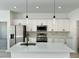 Bright white kitchen with a center island, stainless steel appliances, and modern pendant lights at 273 Marion Oaks Golf Rd, Ocala, FL 34473