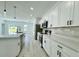 Bright white kitchen with a center island, stainless steel appliances, and light-colored wood floors at 273 Marion Oaks Golf Rd, Ocala, FL 34473