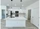 Bright white kitchen with a center island, stainless steel appliances, and modern pendant lights at 273 Marion Oaks Golf Rd, Ocala, FL 34473
