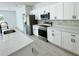 Bright white kitchen with stainless steel appliances and light-colored wood floors at 273 Marion Oaks Golf Rd, Ocala, FL 34473