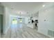 Bright open-concept living room with light-colored wood floors and a modern chandelier at 273 Marion Oaks Golf Rd, Ocala, FL 34473