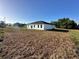 Rear view of a modern white home with a well-manicured lawn and sliding glass doors at 273 Marion Oaks Golf Rd, Ocala, FL 34473