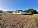 Rear view of a modern white home with a well-manicured lawn and sliding glass doors at 273 Marion Oaks Golf Rd, Ocala, FL 34473
