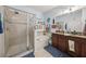 Bathroom with granite double sink vanity, soaking tub, and a glass-enclosed walk-in shower at 34423 Alameda Dr, Sorrento, FL 32776