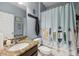 Bright bathroom with a granite countertop and surfboard-themed shower curtain at 34423 Alameda Dr, Sorrento, FL 32776