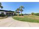 Charming clubhouse entrance with a walkway, palm trees, and golf carts, welcoming residents and guests at 34423 Alameda Dr, Sorrento, FL 32776