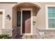 Close-up of a charming front door entrance featuring stone accents, a 