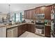 Functional kitchen featuring stainless steel appliances, granite countertops, and dark wood cabinets at 34423 Alameda Dr, Sorrento, FL 32776