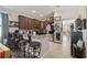 Stylish kitchen featuring granite countertops, brown cabinetry, bar stool seating, and modern appliances at 34423 Alameda Dr, Sorrento, FL 32776