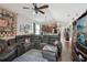 Spacious living room adjacent to an open kitchen with tile flooring, ceiling fan and a large sectional sofa at 34423 Alameda Dr, Sorrento, FL 32776