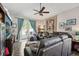 Relaxing living room featuring a ceiling fan, a large sectional sofa, and a door leading to the outdoor space at 34423 Alameda Dr, Sorrento, FL 32776